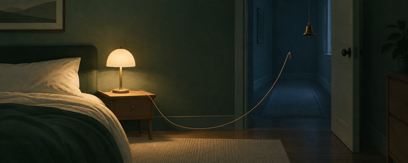 夜の部屋で灯り続けるランプの糸が、廊下の鈴に届かず垂れている。応答があっても周囲へ通知が届かない危うさを表す。